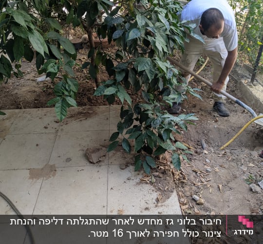 אדם חופר באדמה ליד צינור צהוב ועץ